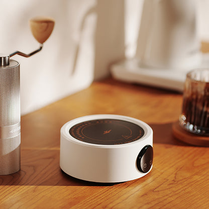 MHW-3BOMBER white mini electric coffee heater with adjustable temperature control on a wooden counter.