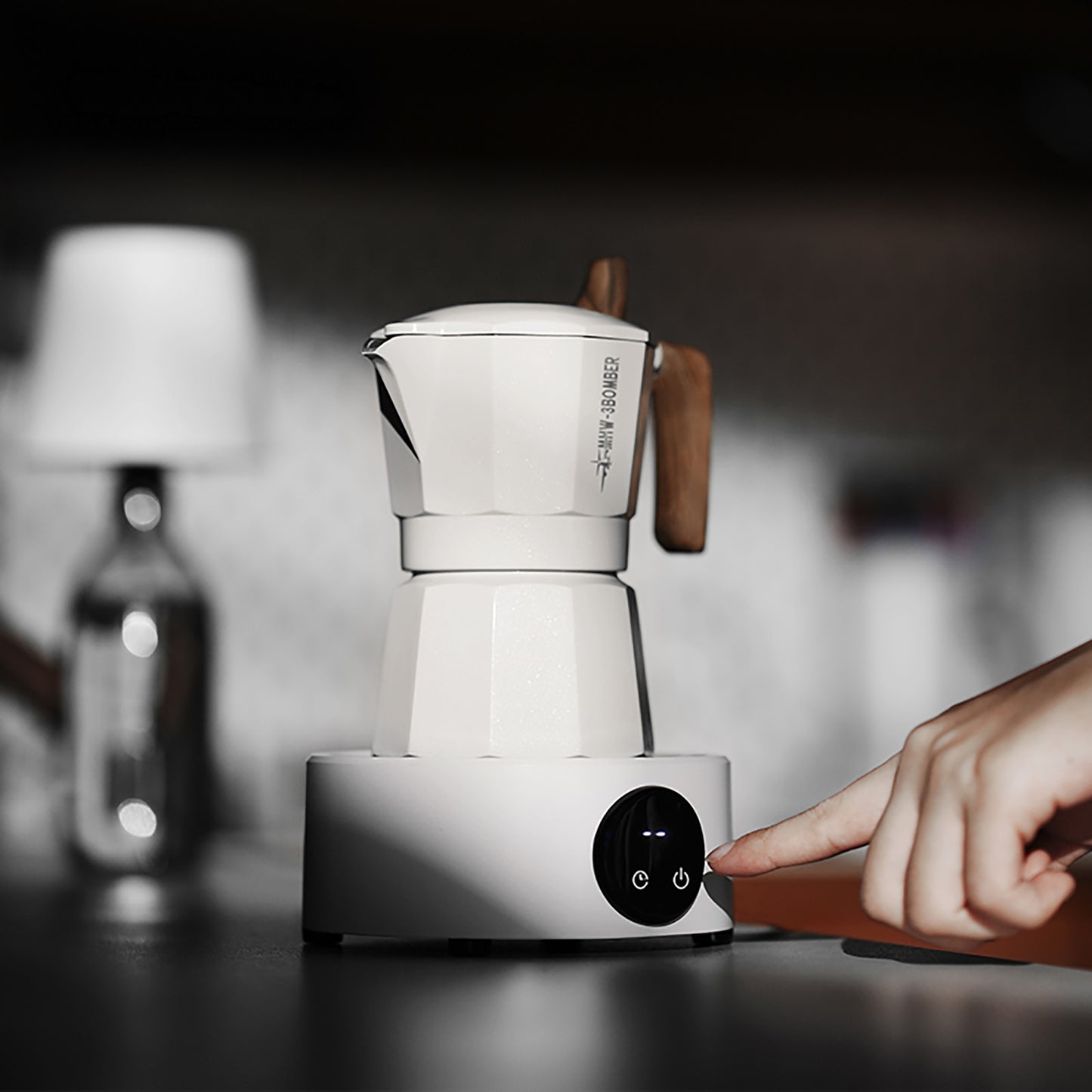 MHW-3BOMBER white electric coffee heater with wood handle and finger pressing power button.