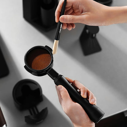 MHW-3BOMBER black portafilter being cleaned with a brush. Espresso making.