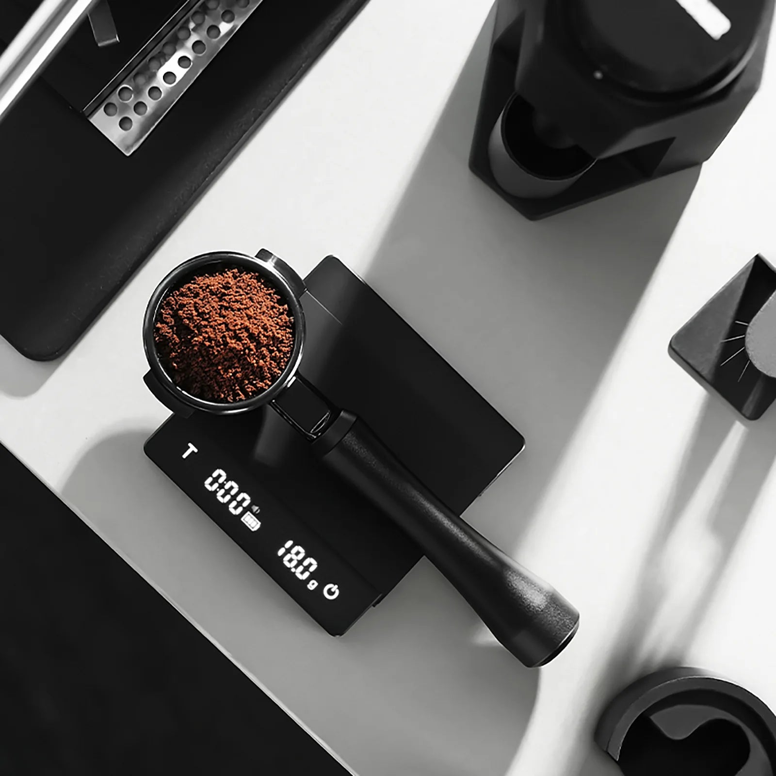 MHW-3BOMBER bottomless portafilter on scale with coffee grounds, black. Espresso setup.