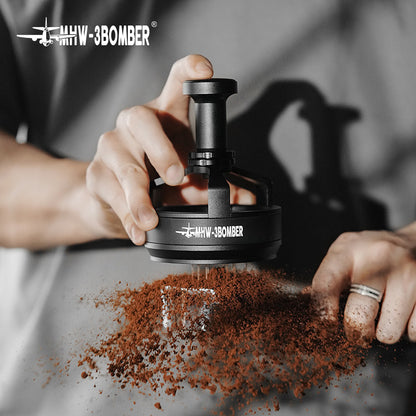 Using the MHW-3BOMBER YU Series Cyclone Needle Distributor WDT Tool, a person expertly distributes and compresses ground coffee, with scattered grounds visible. The focus remains on the tools precision in espresso preparation against a softly blurred background.