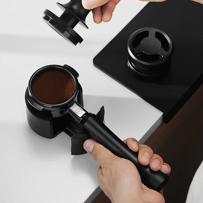 MHW-3BOMBER Astra portafilter set. Includes bottomless portafilter, stand, tamper. Black. Espresso prep on counter.