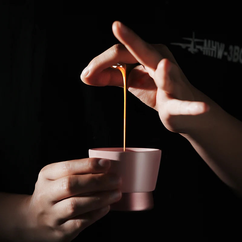 MHW-3BOMBER CERA pink ceramic coffee cup with U-shaped design being filled. Hand washing recommended. 