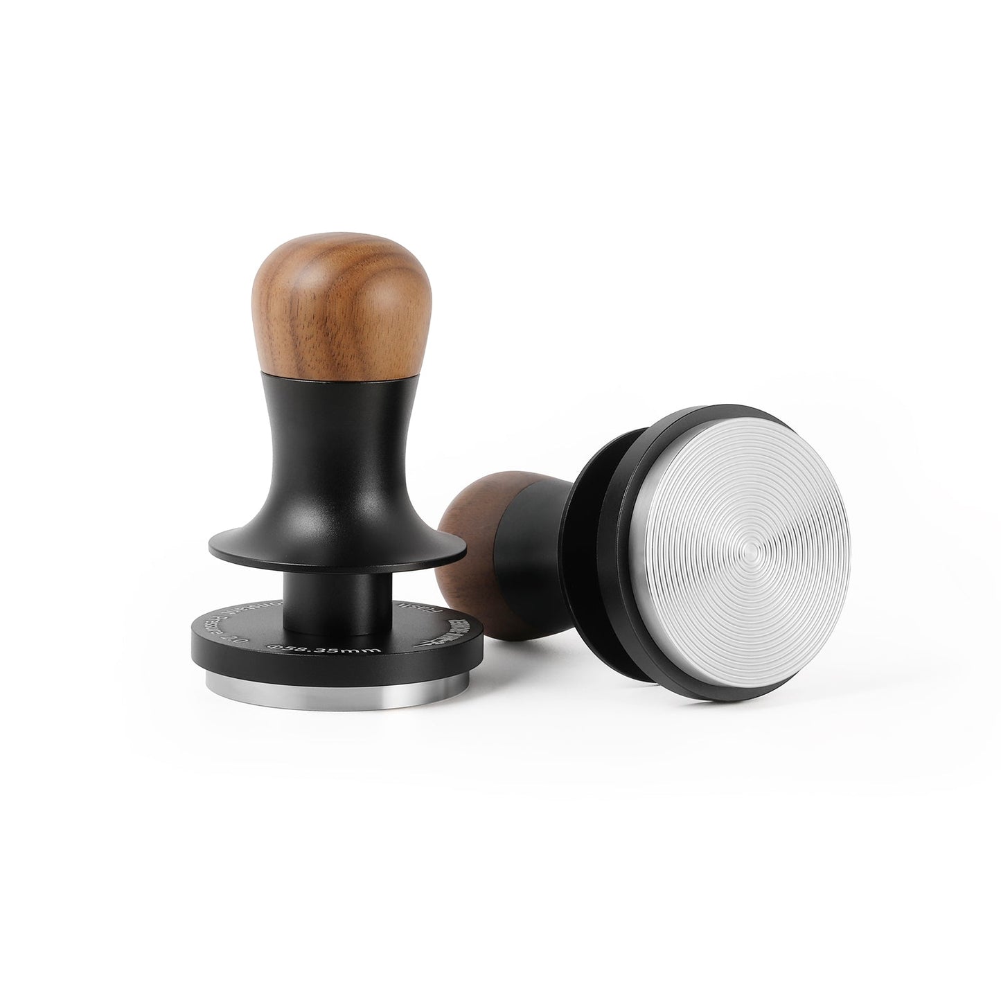 Two MHW-3BOMBER Flash Tampers are shown: one upright, the other on its side. Both have ergonomic wooden handles, black collars, and polished metal bases. The base of the horizontal tamper reveals a textured surface with concentric circles.