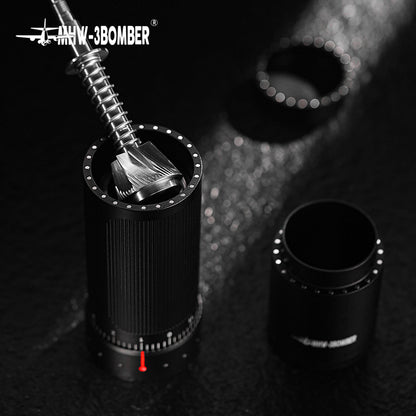 A black MHW-3BOMBER Blade R3 Manual Coffee Grinder with a textured exterior highlights its stainless steel burr assembly. Grinder parts and a cover sit on a dark surface. The HW-3BOMBER logo appears in the corner, symbolizing precision and quality craftsmanship.