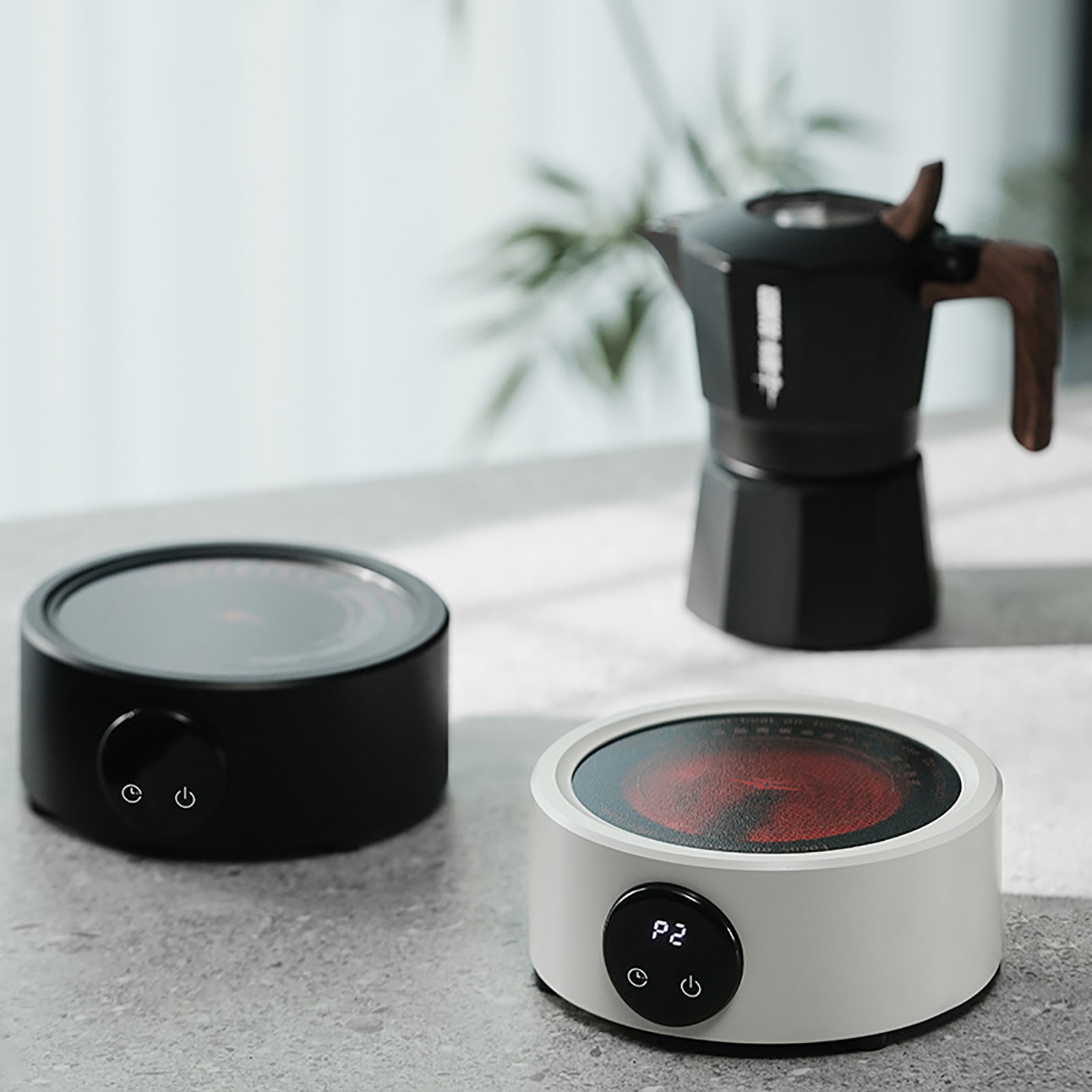 MHW-3BOMBER electric coffee heater in black and white, with moka pot. Compact and portable.