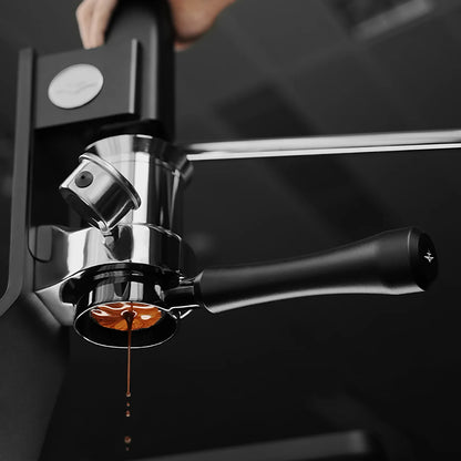 MHW-3BOMBER Astra portafilter brewing espresso. Silver and black bottomless design. 