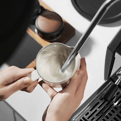 MHW-3BOMBER GT Milk Pitcher glossy white in use, steaming milk for latte art. Premium design.