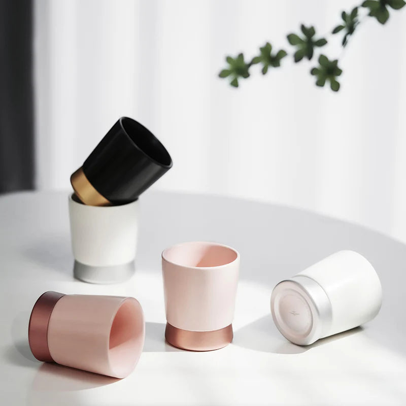 MHW-3BOMBER CERA ceramic cups in white, pink & black with color-blocked metal base. Multi-use design. On table.