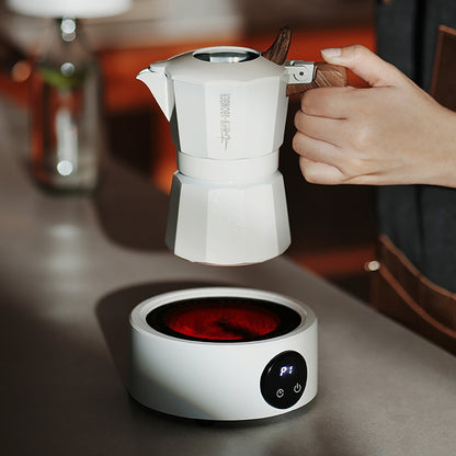 MHW-3BOMBER white Moka pot with wood handle on electric coffee heater. Brewing coffee. 