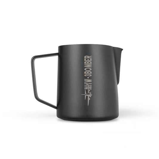 The MHW-3BOMBER Latte Art Pitcher 5.0 in matte black features a crocodile spout, angular handle, and airplane graphic alongside the BOMBER logo. Made of stainless steel, its perfect for precision akin to a milk frother in your kitchenware collection.