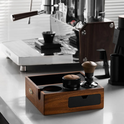 MHW-3BOMBER espresso knock box, walnut wood with black drawer, tamper and coffee distributor on counter. 