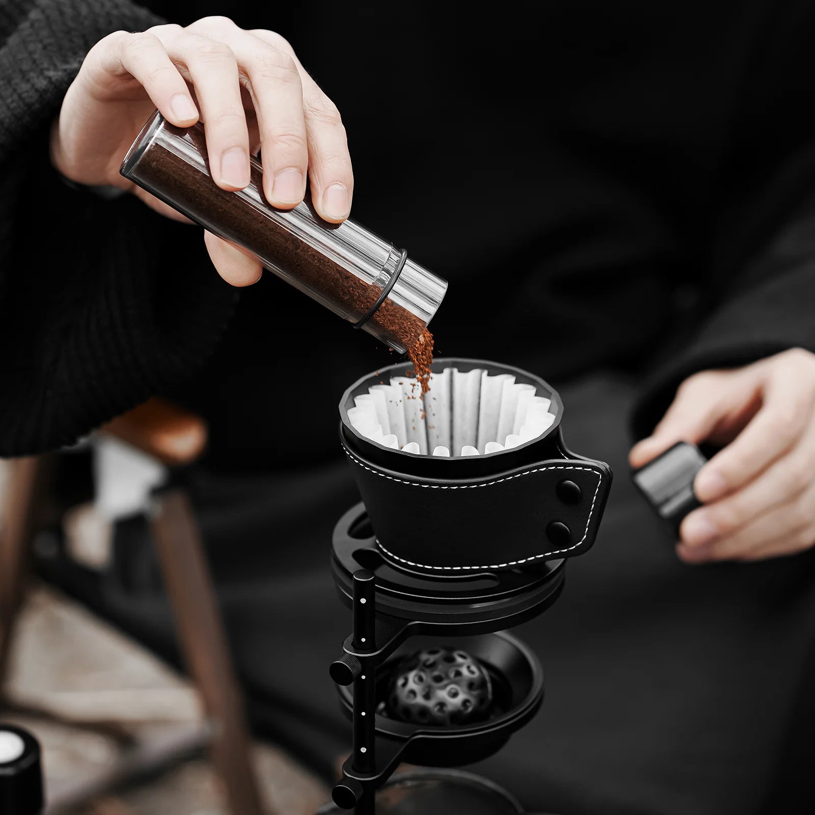 MHW-3BOMBER black Meteorite Dripper being used to pour coffee. Unique rib design, anti-scald holster. 